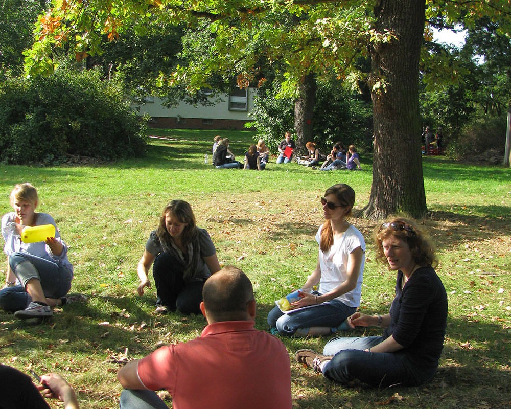 Gruppen von Menschen im Garten des Naturfreundehauses Hannover.